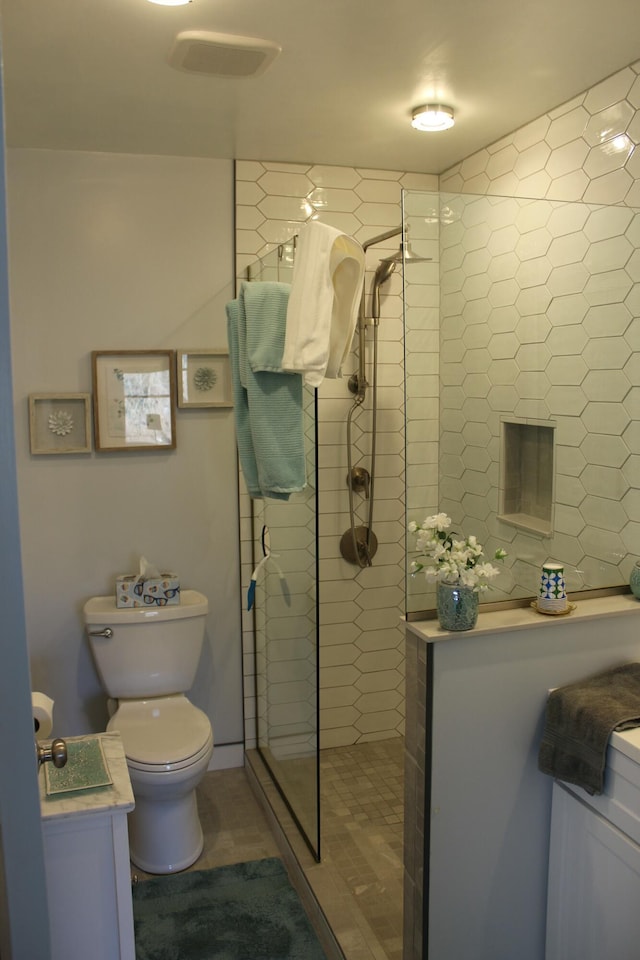 bathroom featuring toilet, walk in shower, and vanity