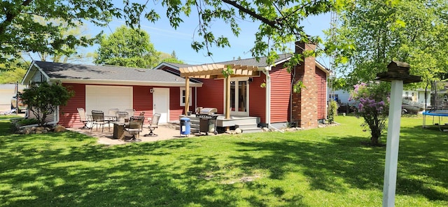 rear view of house featuring a trampoline, a chimney, a lawn, a patio area, and a pergola