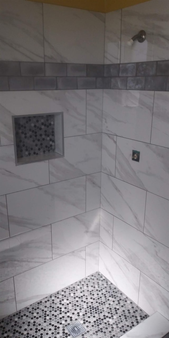 interior details featuring a tile shower