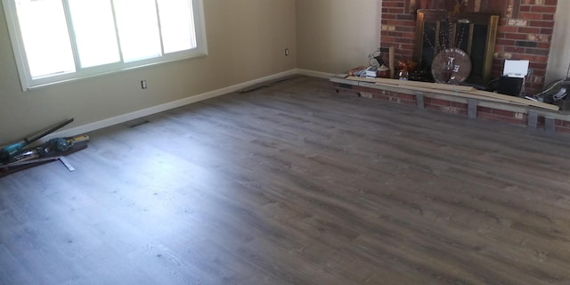 unfurnished living room featuring wood finished floors and baseboards