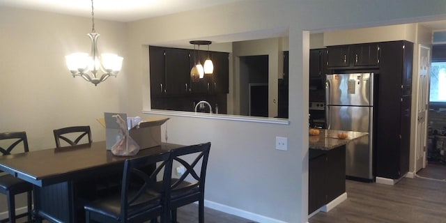 dining area with a notable chandelier, baseboards, and wood finished floors