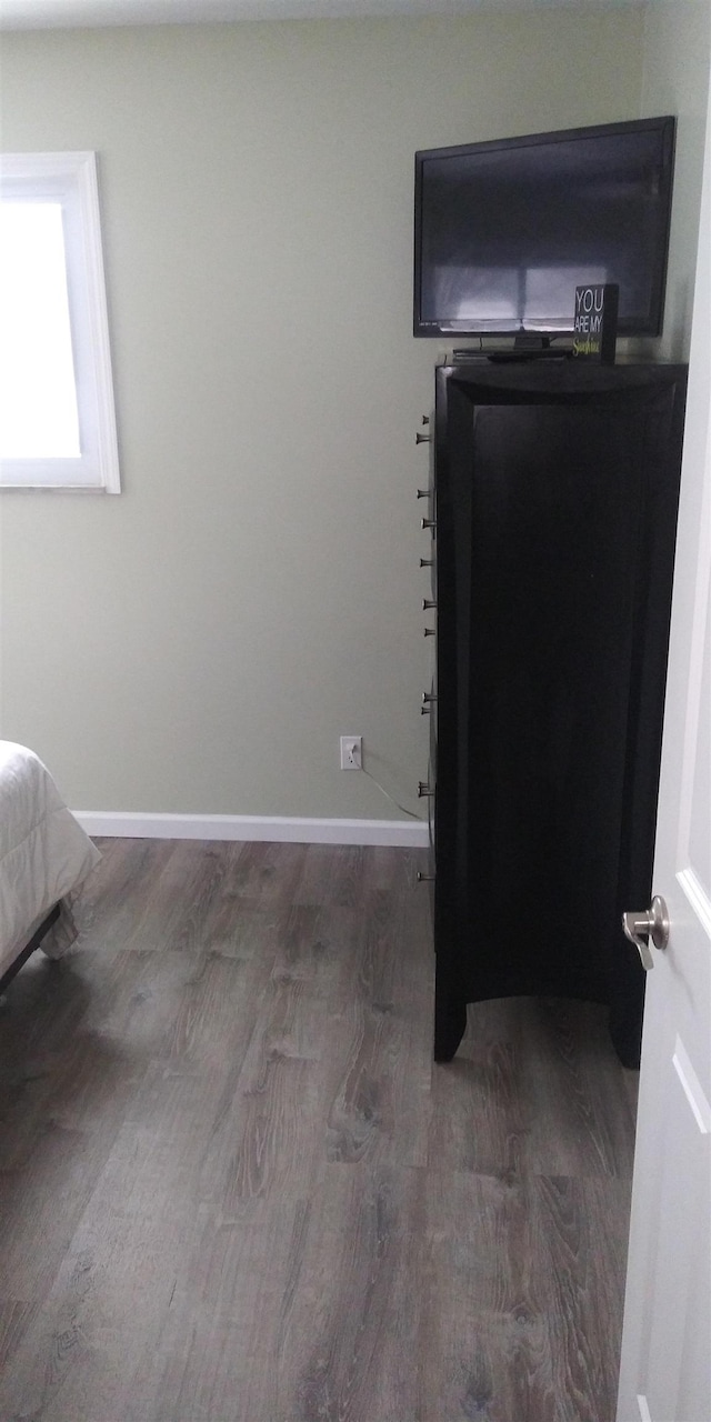 bedroom with baseboards and wood finished floors