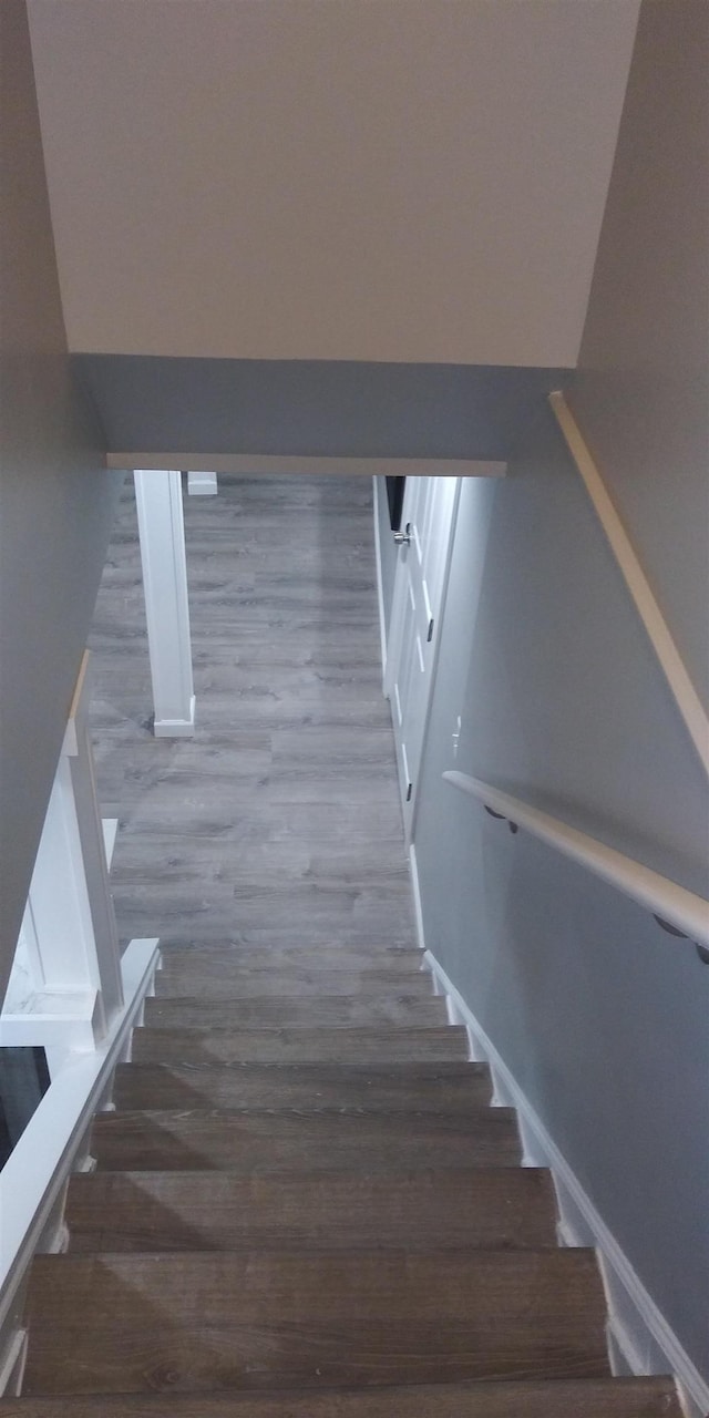 stairs with wood finished floors and baseboards