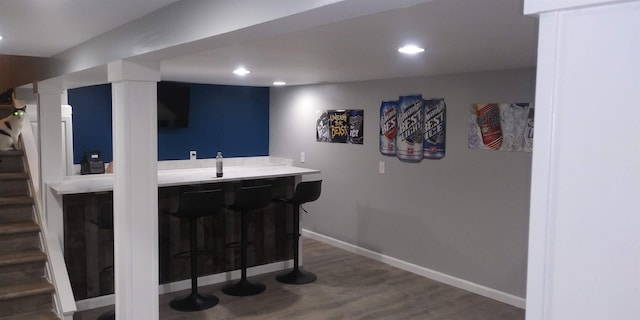 bar with stairs, baseboards, wood finished floors, and recessed lighting