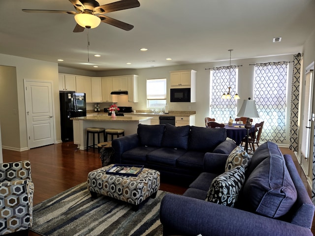 living area featuring baseboards, dark wood-style flooring, a ceiling fan, and recessed lighting