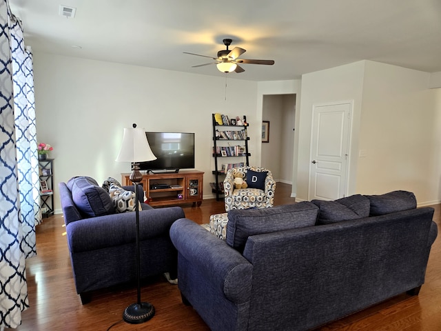 living room featuring baseboards, ceiling fan, visible vents, and wood finished floors