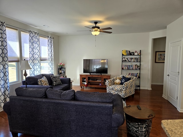 living room with dark wood-style floors, ceiling fan, visible vents, and baseboards