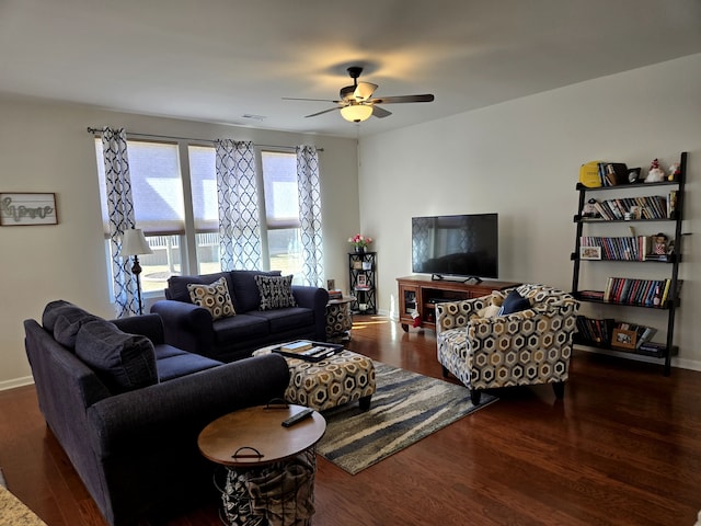 living room featuring ceiling fan, visible vents, baseboards, and wood finished floors