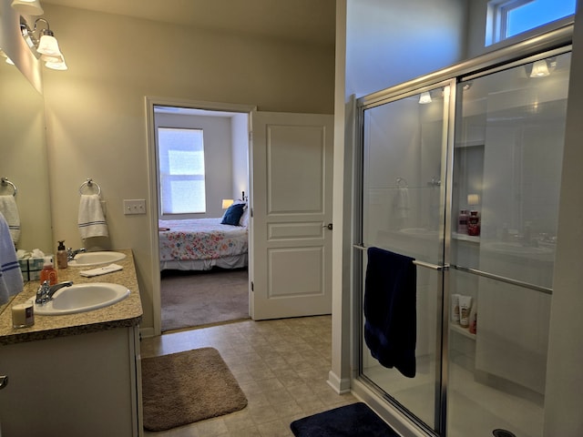 ensuite bathroom with a healthy amount of sunlight, a sink, a shower stall, and double vanity