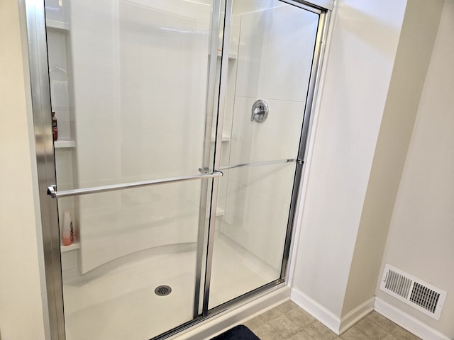 full bath featuring a stall shower, visible vents, and baseboards