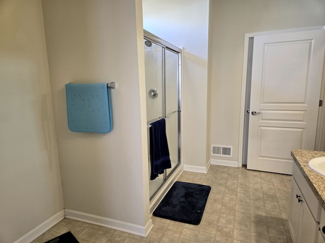 bathroom featuring baseboards, visible vents, a shower stall, and vanity