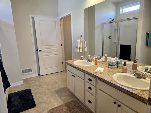 full bath with double vanity, a shower stall, visible vents, and a sink