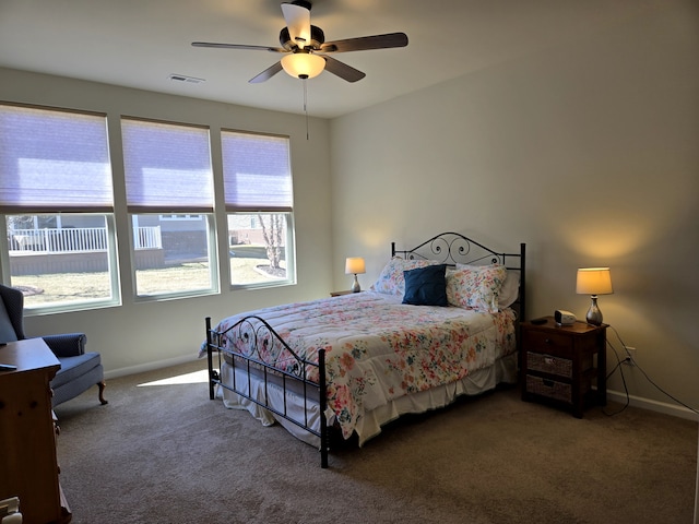 carpeted bedroom featuring a ceiling fan, visible vents, and baseboards