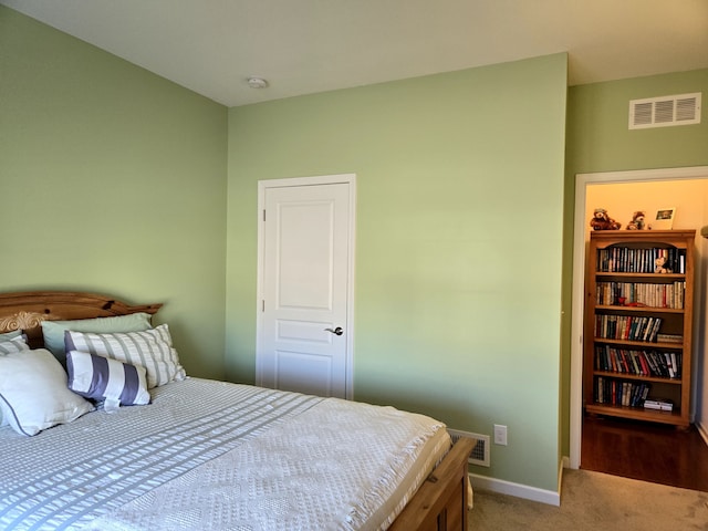 bedroom with carpet, visible vents, and baseboards