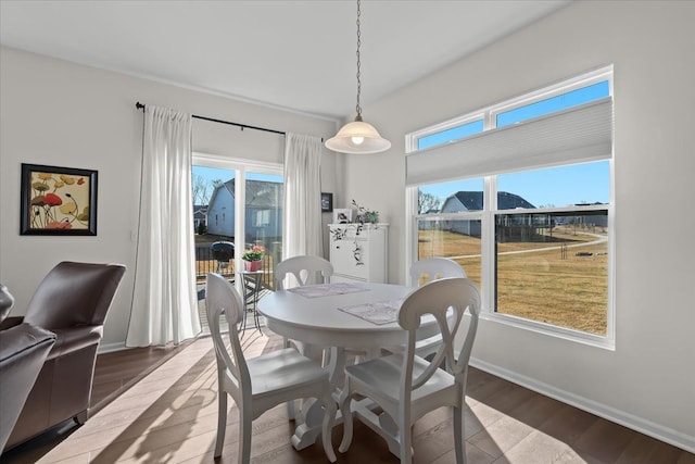 dining space featuring wood finished floors and baseboards