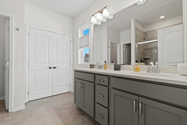 full bath featuring double vanity, a stall shower, and a sink