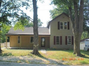 view of front of home with an outdoor structure and a front yard