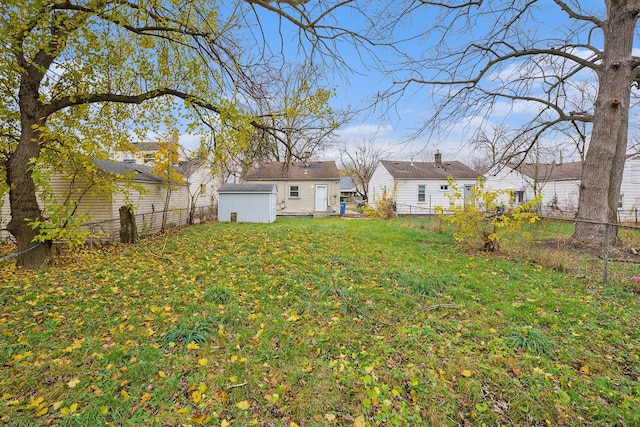 view of yard featuring an outbuilding, fence, and a storage shed