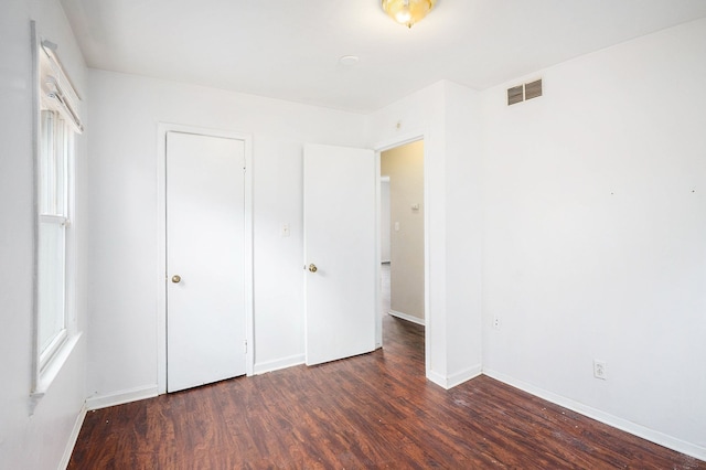 unfurnished bedroom with visible vents, baseboards, and wood finished floors