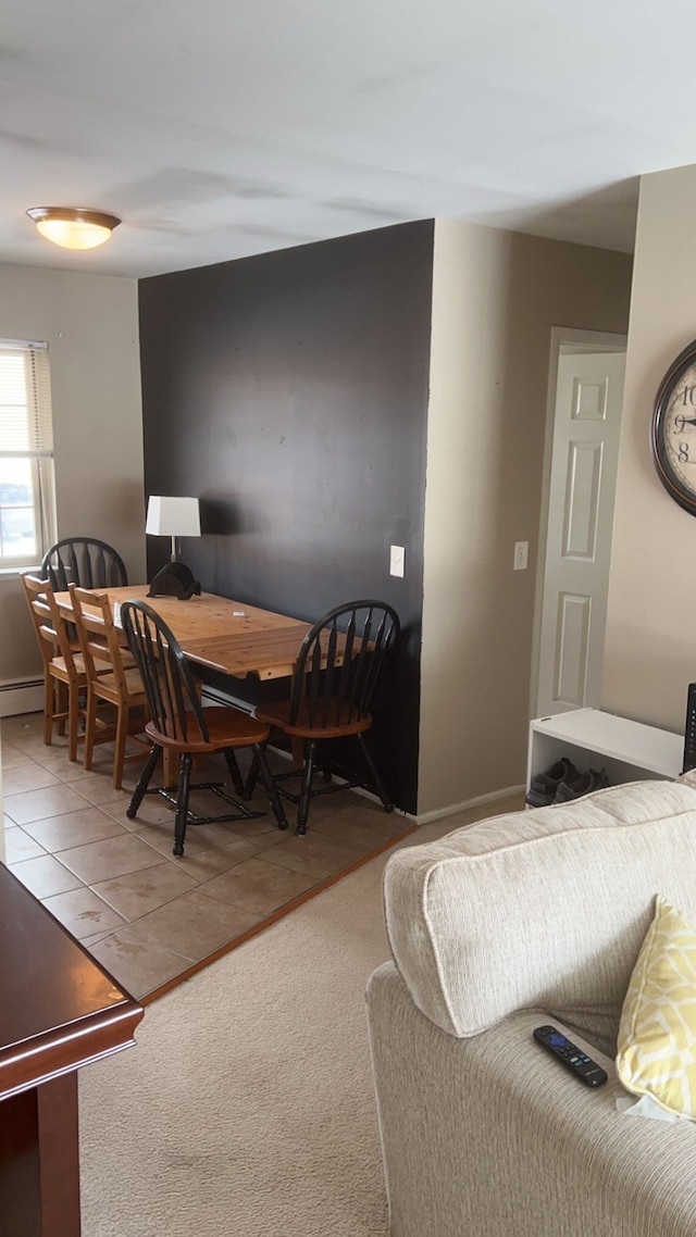 carpeted dining room with a baseboard radiator and tile patterned flooring