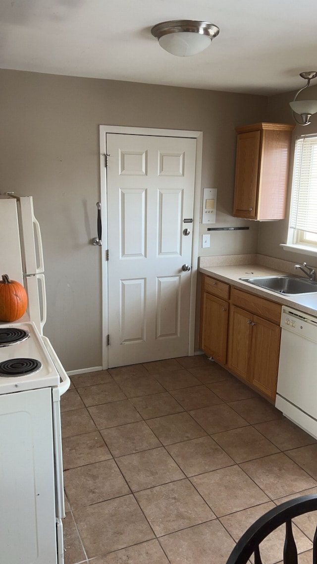 kitchen with light countertops, white appliances, light tile patterned flooring, and a sink