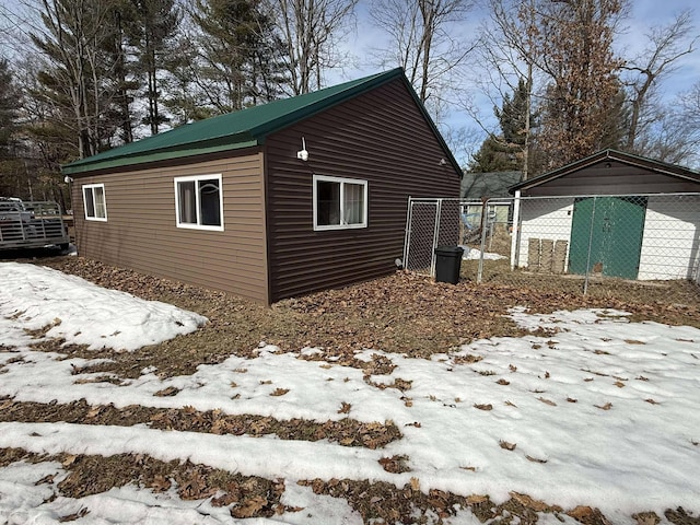 view of snowy exterior with an outdoor structure