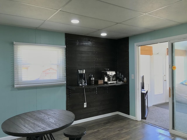 bar featuring a paneled ceiling, dark wood-style floors, visible vents, and a wealth of natural light