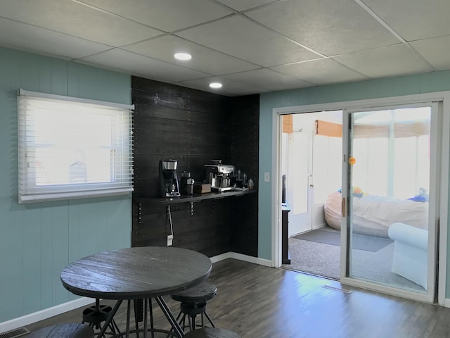 kitchen featuring a paneled ceiling, visible vents, baseboards, and dark wood finished floors