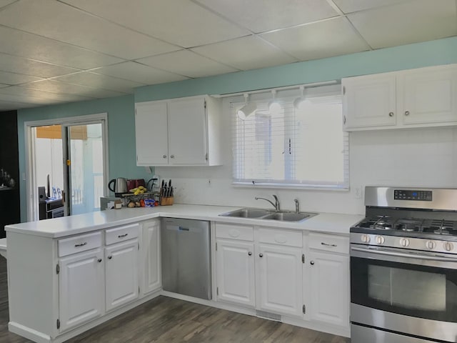 kitchen featuring appliances with stainless steel finishes, white cabinetry, a sink, and a peninsula