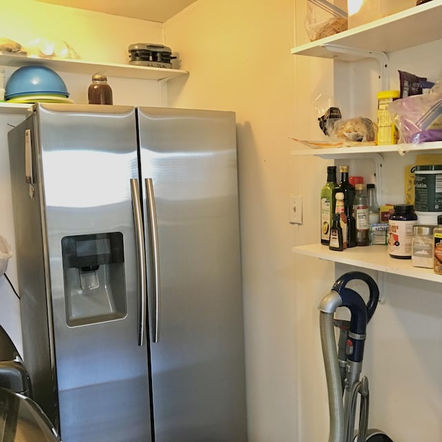 kitchen with open shelves and stainless steel refrigerator with ice dispenser