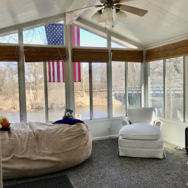 sunroom with a healthy amount of sunlight, vaulted ceiling, a water view, and ceiling fan