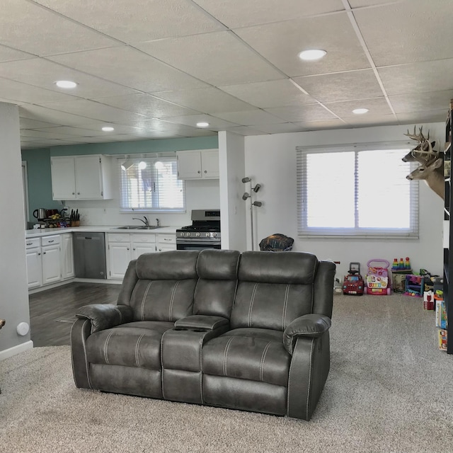 living area featuring a drop ceiling and recessed lighting