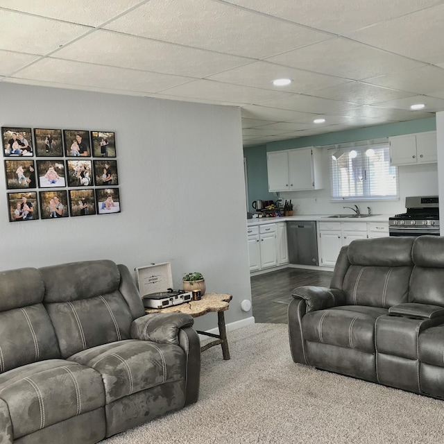 living room with dark colored carpet, recessed lighting, a drop ceiling, and baseboards