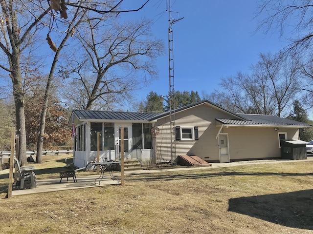 rear view of house with metal roof, a patio, a standing seam roof, and a sunroom