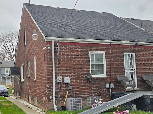 5516 Audubon Rd, Detroit, MI 48224 - view of home's exterior featuring brick siding, cooling unit, and roof with shingles