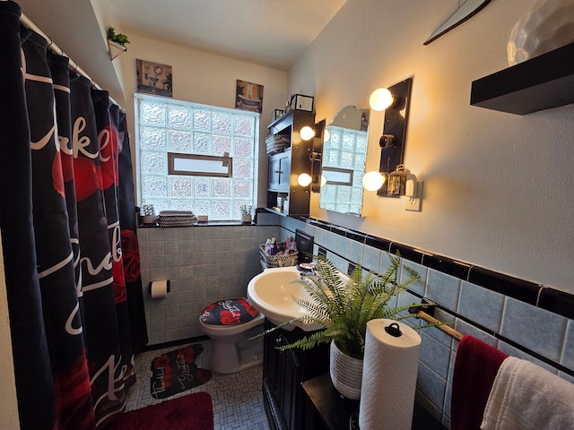 5516 Audubon Rd, Detroit, MI 48224 - bathroom featuring toilet, tile walls, wainscoting, tile patterned flooring, and vanity