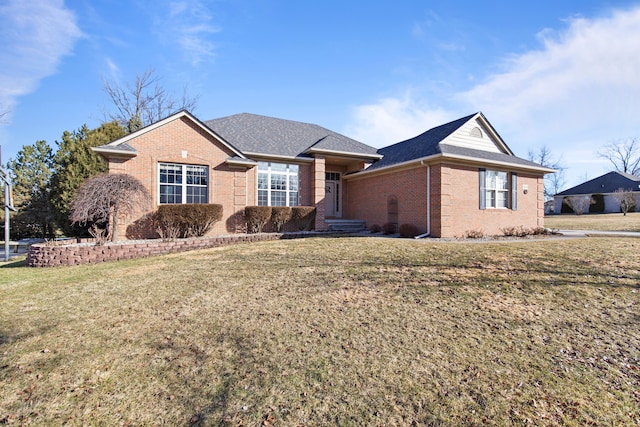 ranch-style house featuring brick siding, roof with shingles, and a front yard