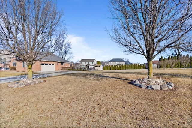 view of yard featuring a residential view, a garage, and fence