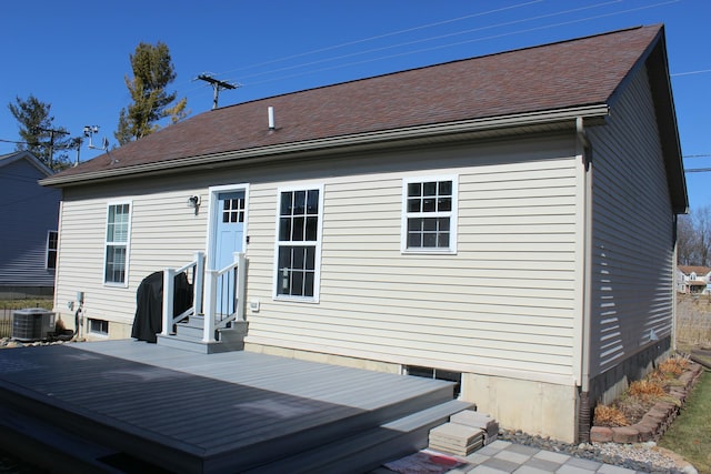 rear view of property with entry steps, a shingled roof, and central air condition unit