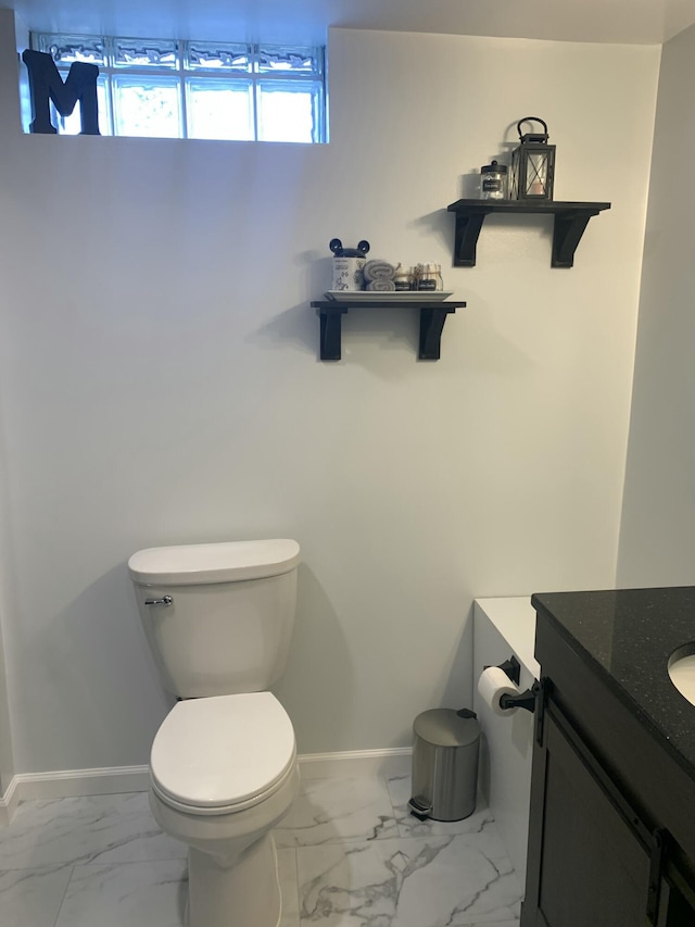 bathroom featuring marble finish floor, toilet, vanity, and baseboards