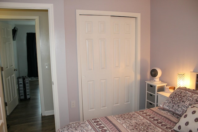 bedroom with dark wood-style floors and a closet