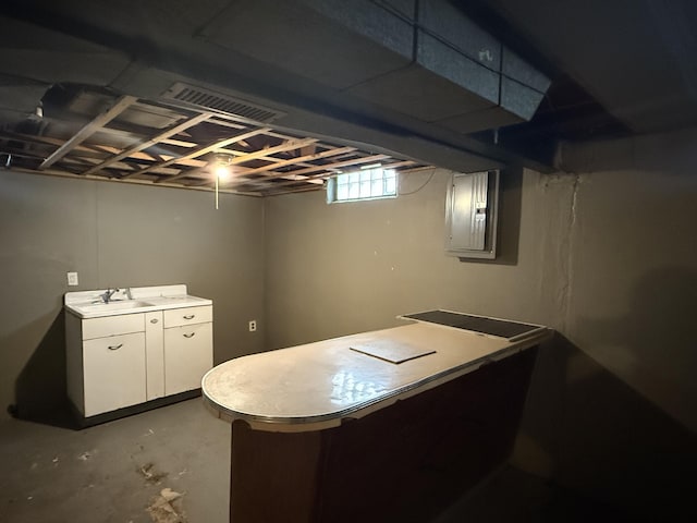 basement with visible vents, a sink, and electric panel