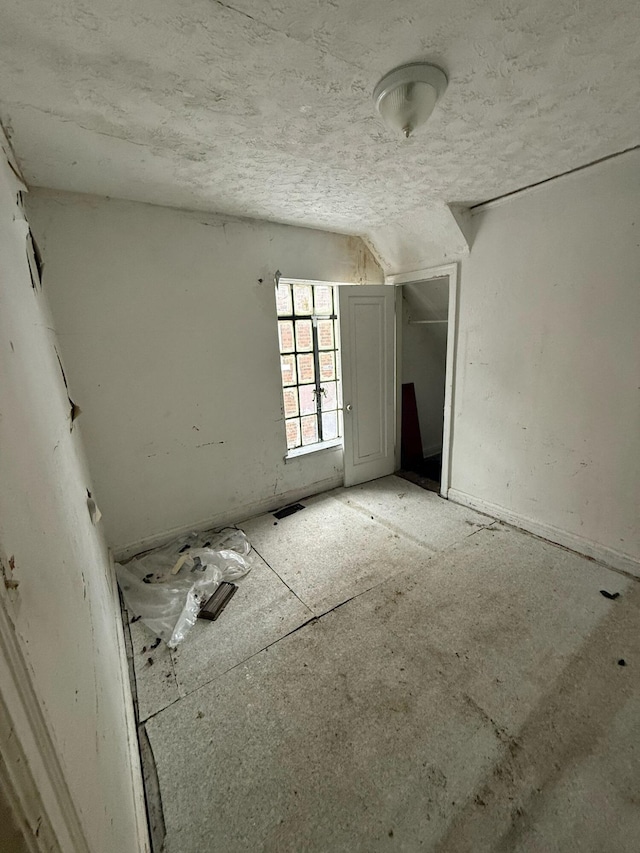 spare room featuring lofted ceiling