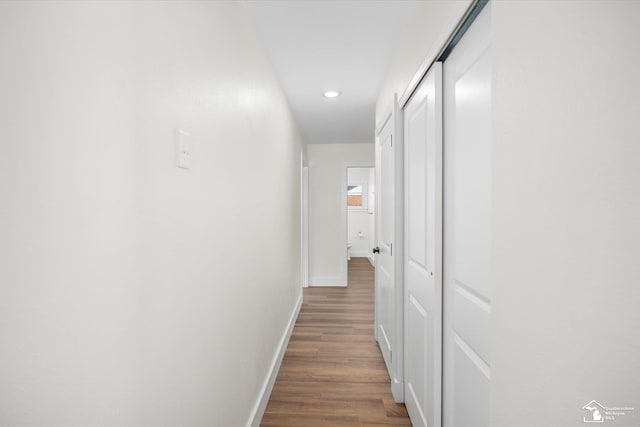 hall with baseboards, wood finished floors, and recessed lighting