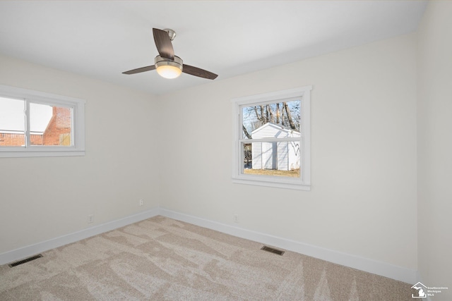 empty room with light colored carpet, visible vents, and baseboards