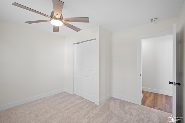 unfurnished bedroom with carpet, a closet, ceiling fan, and baseboards