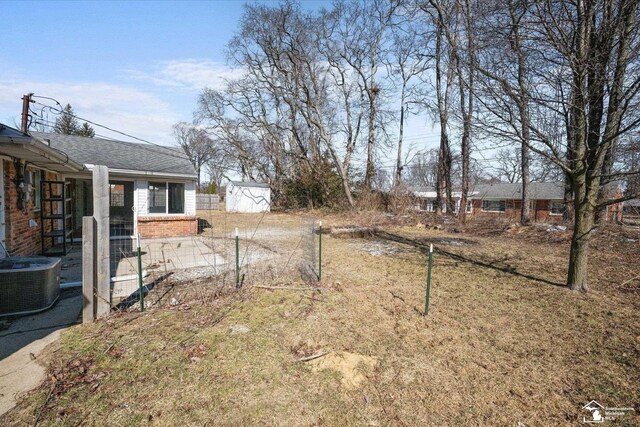 view of yard with an outbuilding, a shed, and central air condition unit