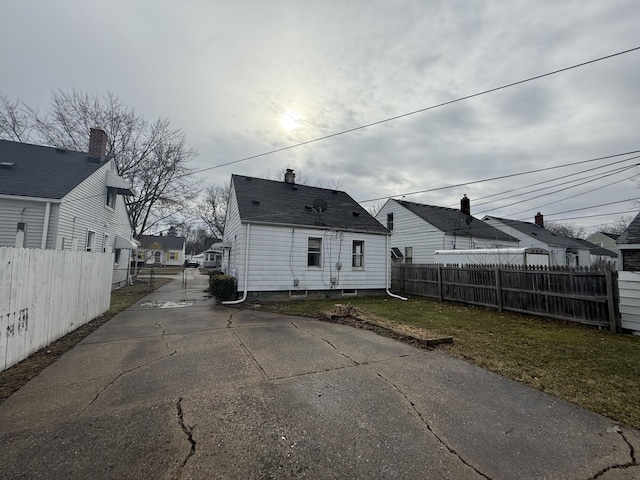 back of property with a residential view, fence, and a yard