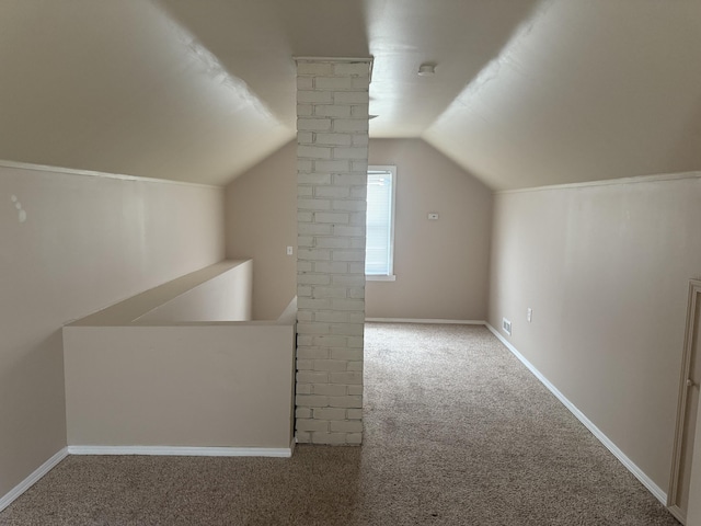 additional living space with decorative columns, baseboards, vaulted ceiling, and carpet flooring