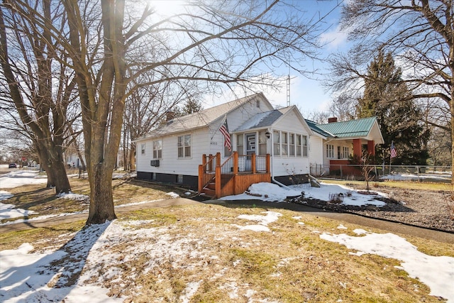 view of front of home with a wooden deck, a chimney, and fence